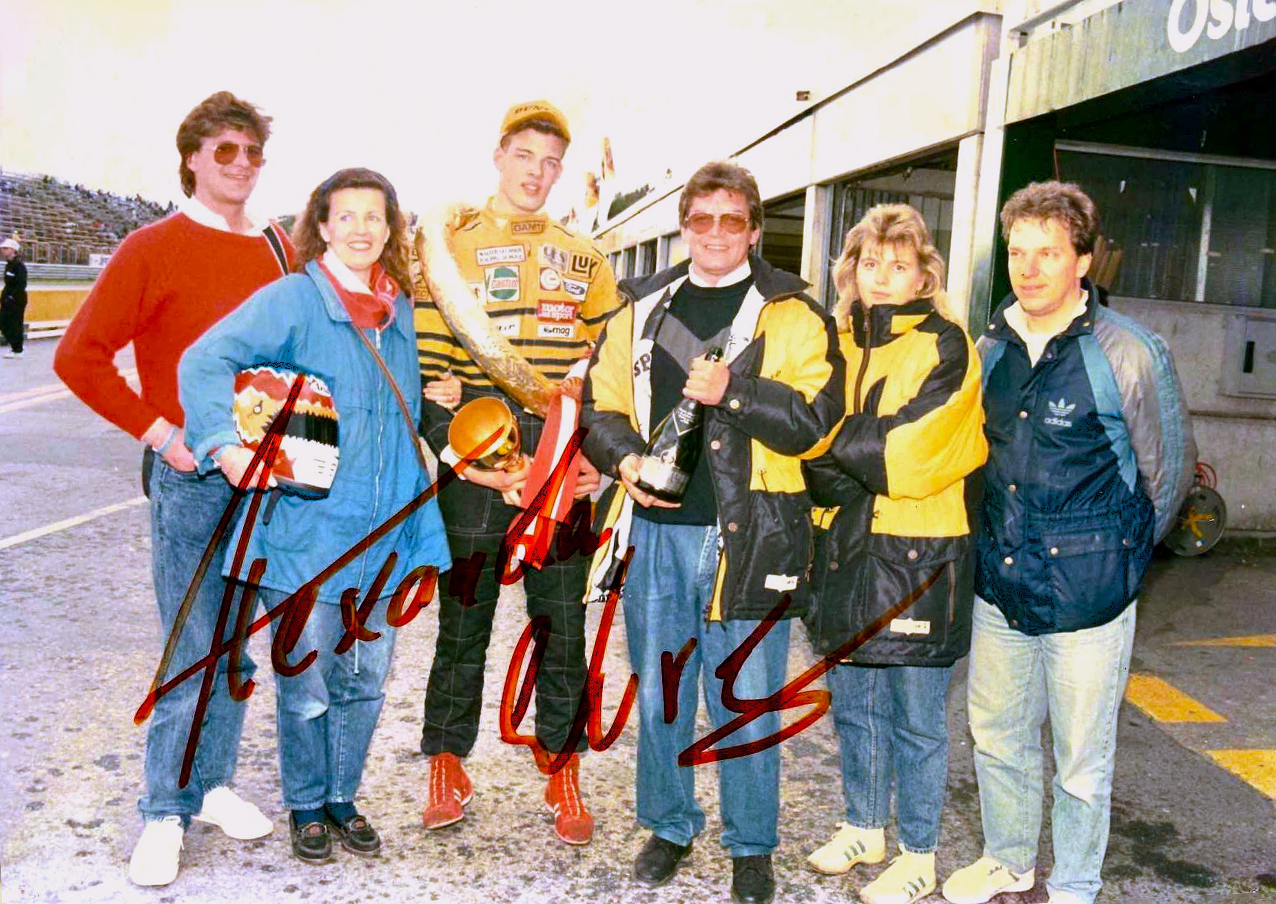 Auf dem Bild sieht man eine Gruppe von Personen vor Garagen stehen.