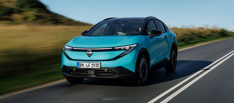 Ein türkiser Nissan Leaf von vorn auf einer Landstraße