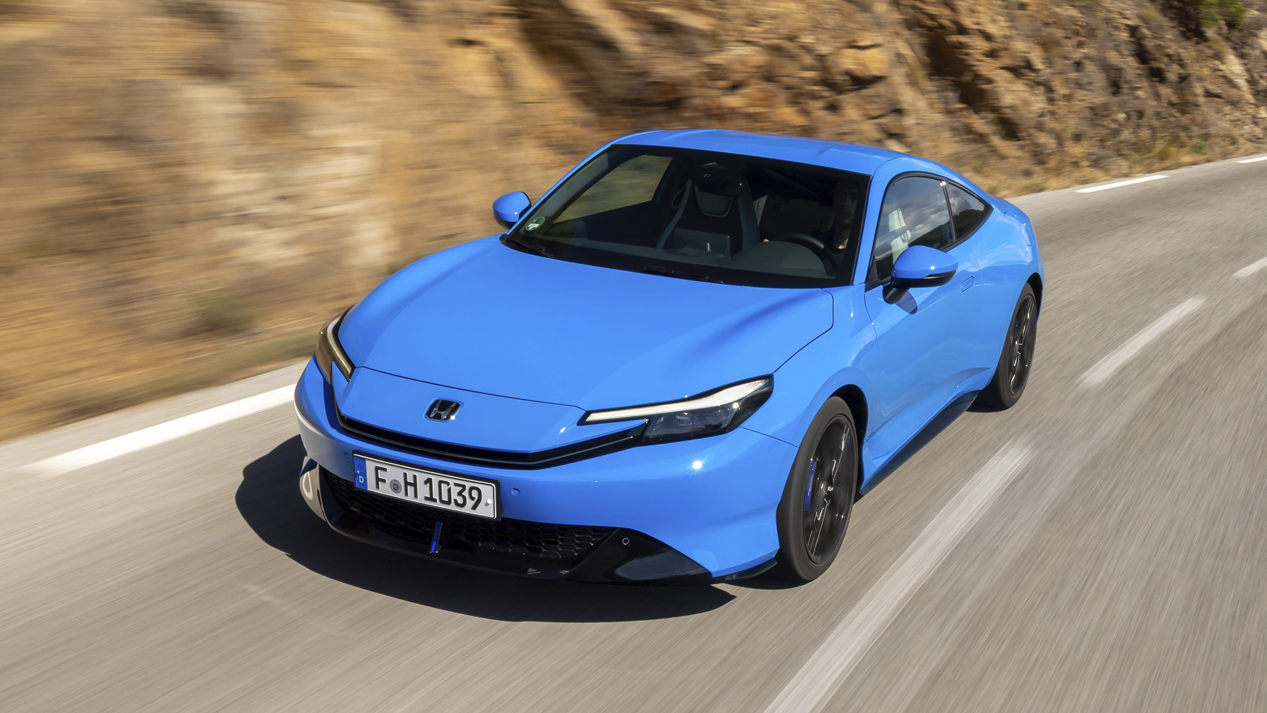 Ein blauer Honda Prelude 2025 fährt über eine Landstraße.