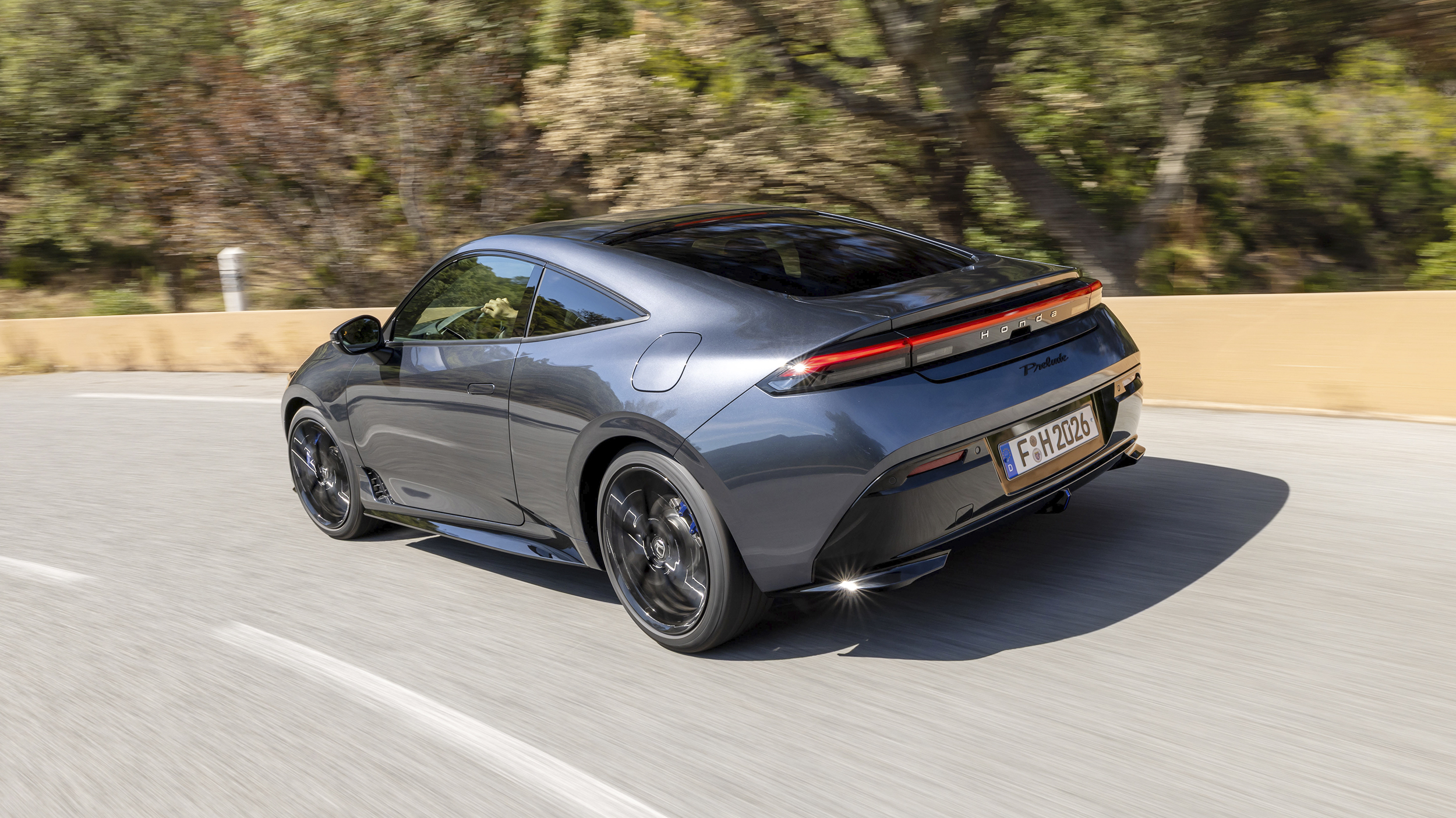 Ein grauer Honda Prelude 2025 fährt über eine Landstraße.