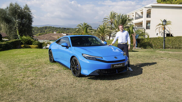 Eine Person steht neben einem blauen Honda Prelude.