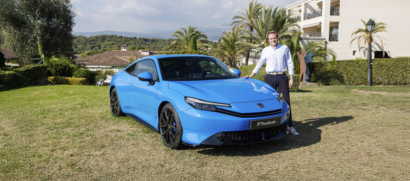 Eine Person steht neben einem blauen Honda Prelude.