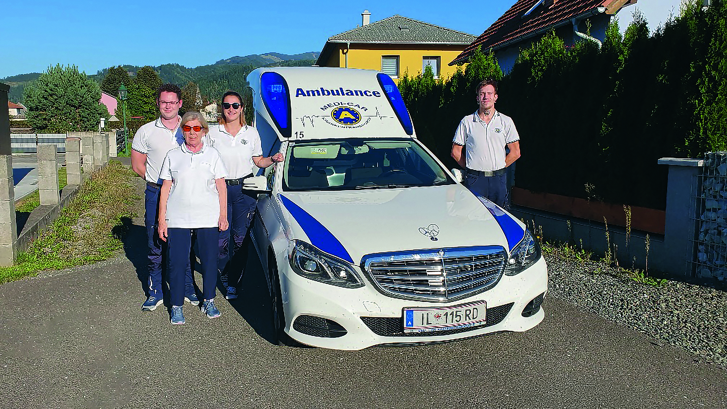 ÖAMTC-Clubmitglieder stehen gemeinsam mit Sanitätern vor einem Krankenfahrzeug.