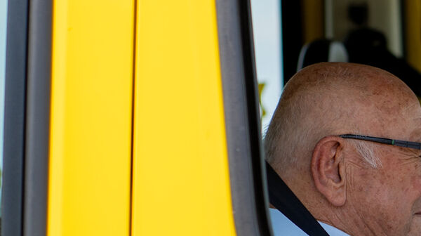 Auf dem Bild sieht man einen kleinen Ausschnitt, Durch ein offenes Autofenster wurden ein alter und ein junger Mann fotografiert.