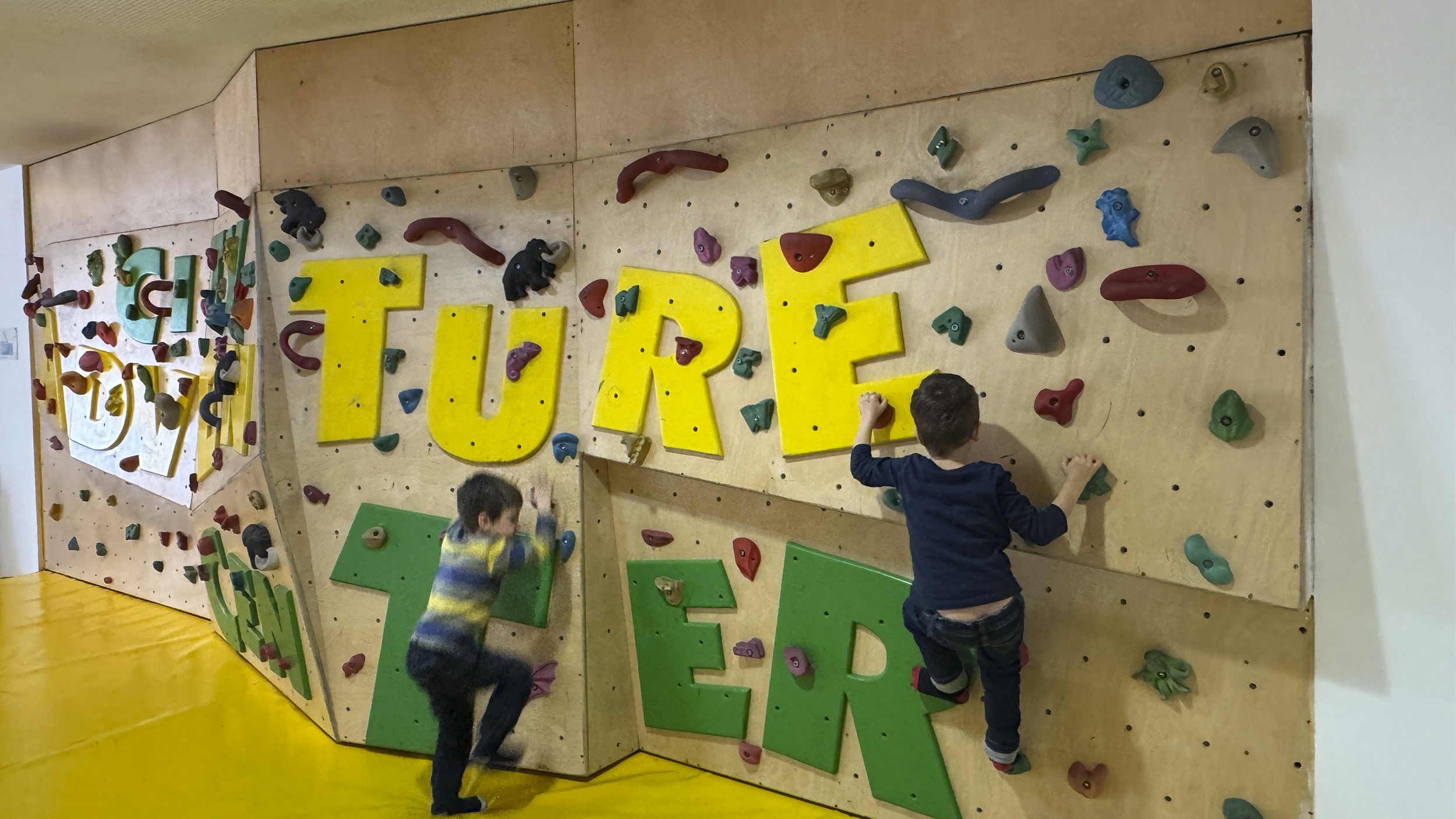 drei Kinder spielen und Klettern in der Kinder-Bereich im Jufa-Hotel.