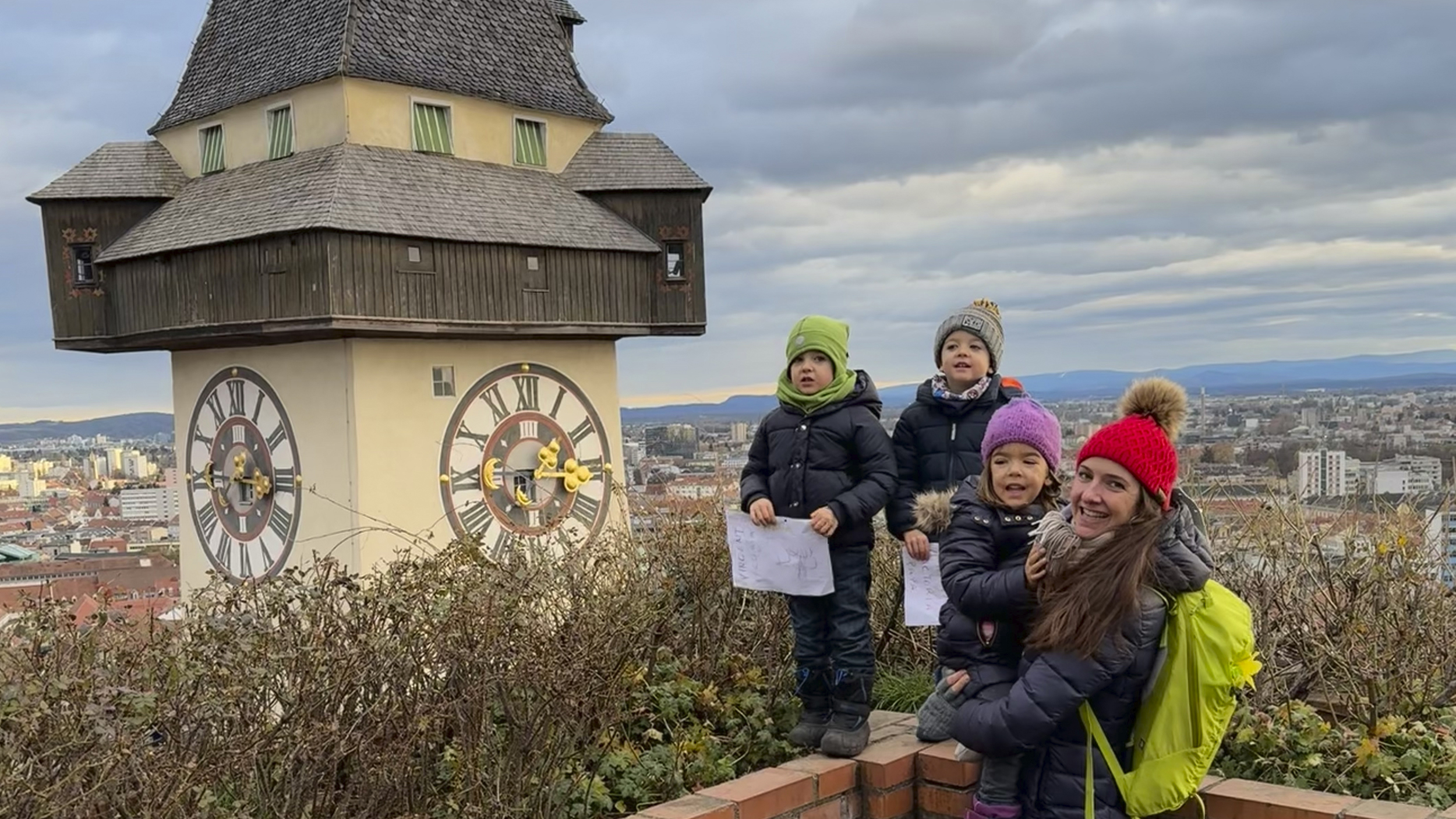 Redakteurin Conny mit ihren Drillingen am Schlossberg in Graz neben dem Uhrturm. 