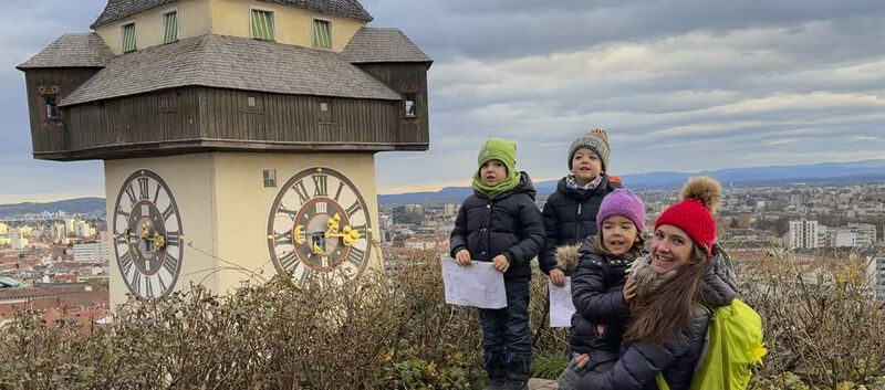 Redakteurin Conny mit ihren Drillingen am Schlossberg in Graz neben dem Uhrturm.