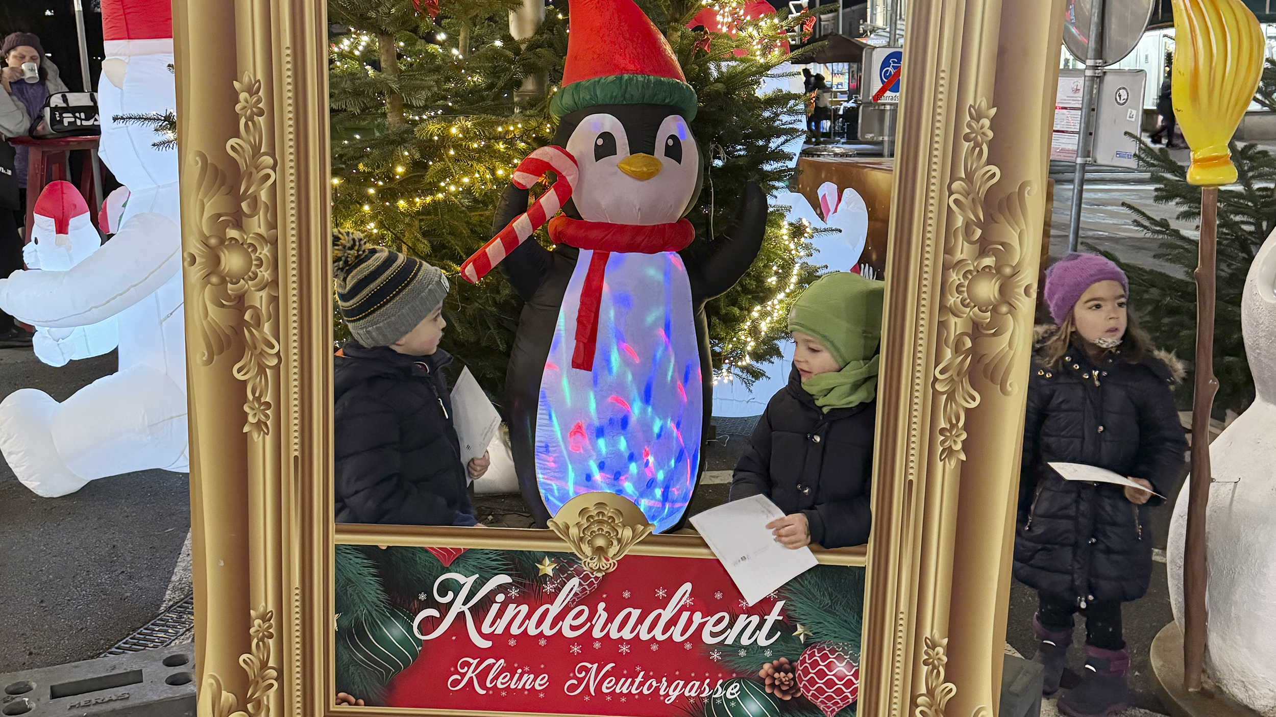 Bilderrahmen mit drei Kindern am Adventmarkt.