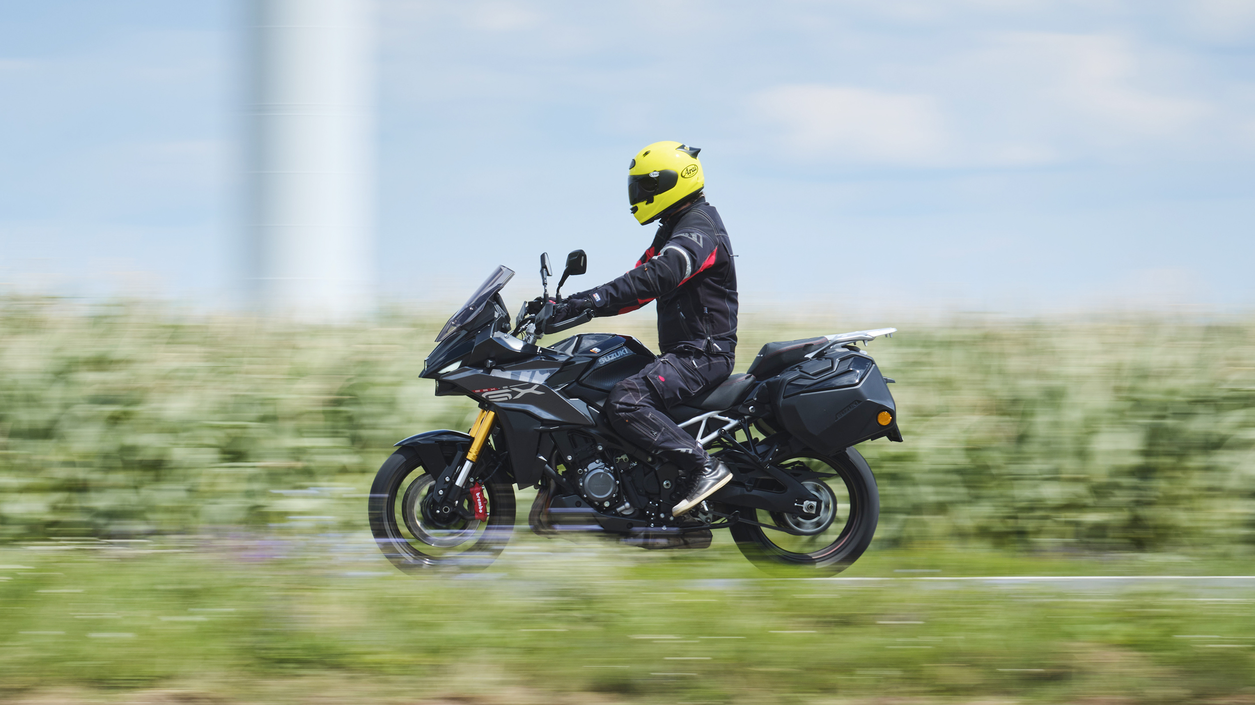 Grauer Sporttourer fahrend seitlich fotografiert.