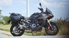 Grauer Sporttourer mit zwei montierten Koffern seitlich fotografiert.