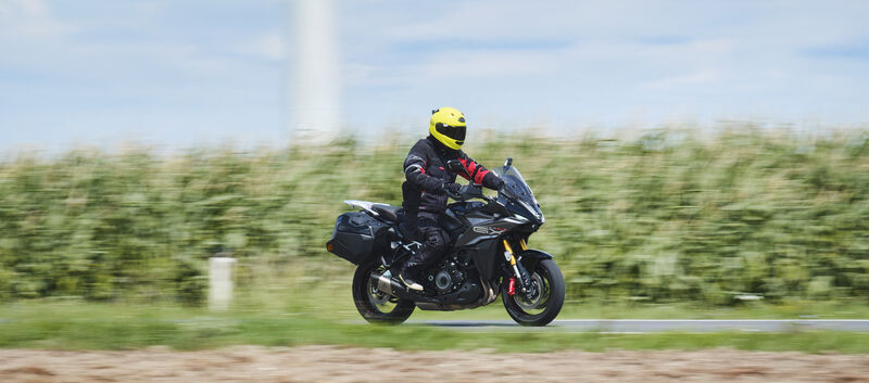 Grauer Sporttourer fahrend von schräg vorne fotografiert.