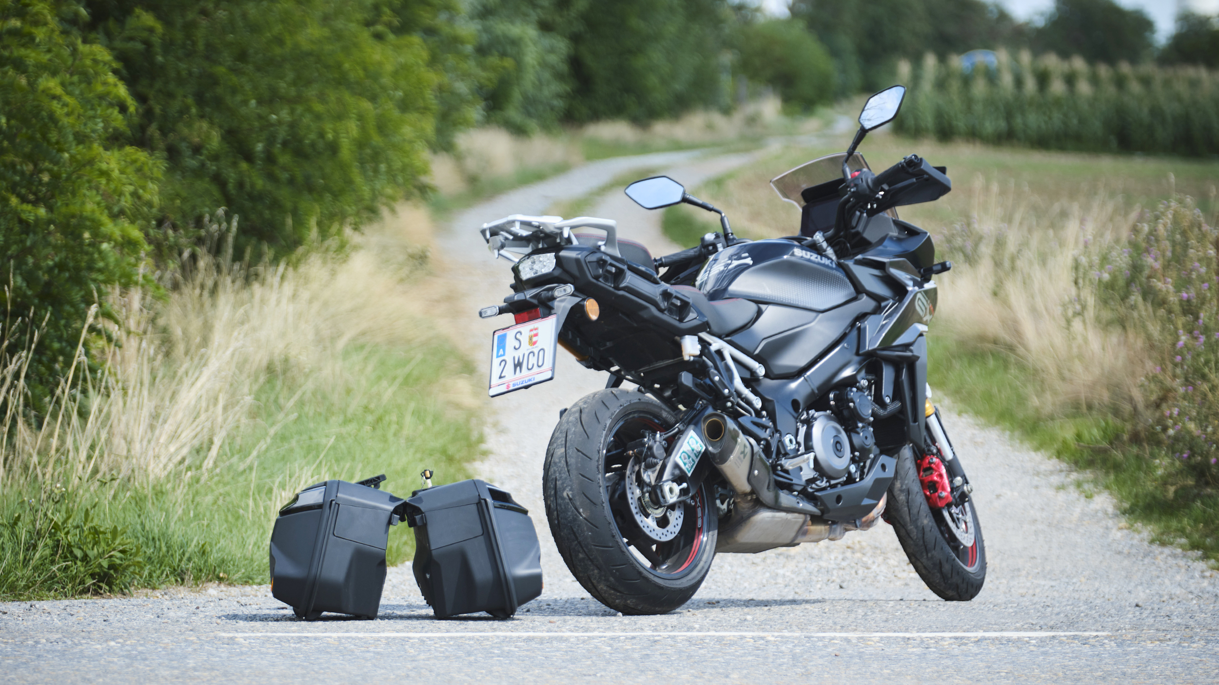 Grauer Sporttourer mit zwei abmontierten Koffern von schräg hinten fotografiert.