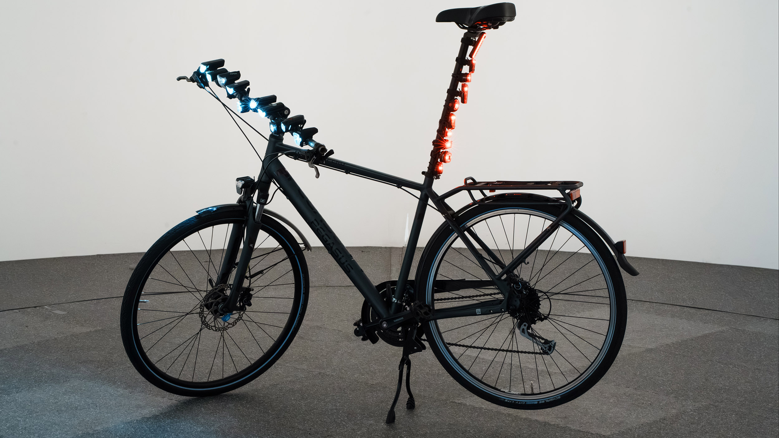 Ein Fahrrad, an dem diverse Beleuchtungen montiert sind.