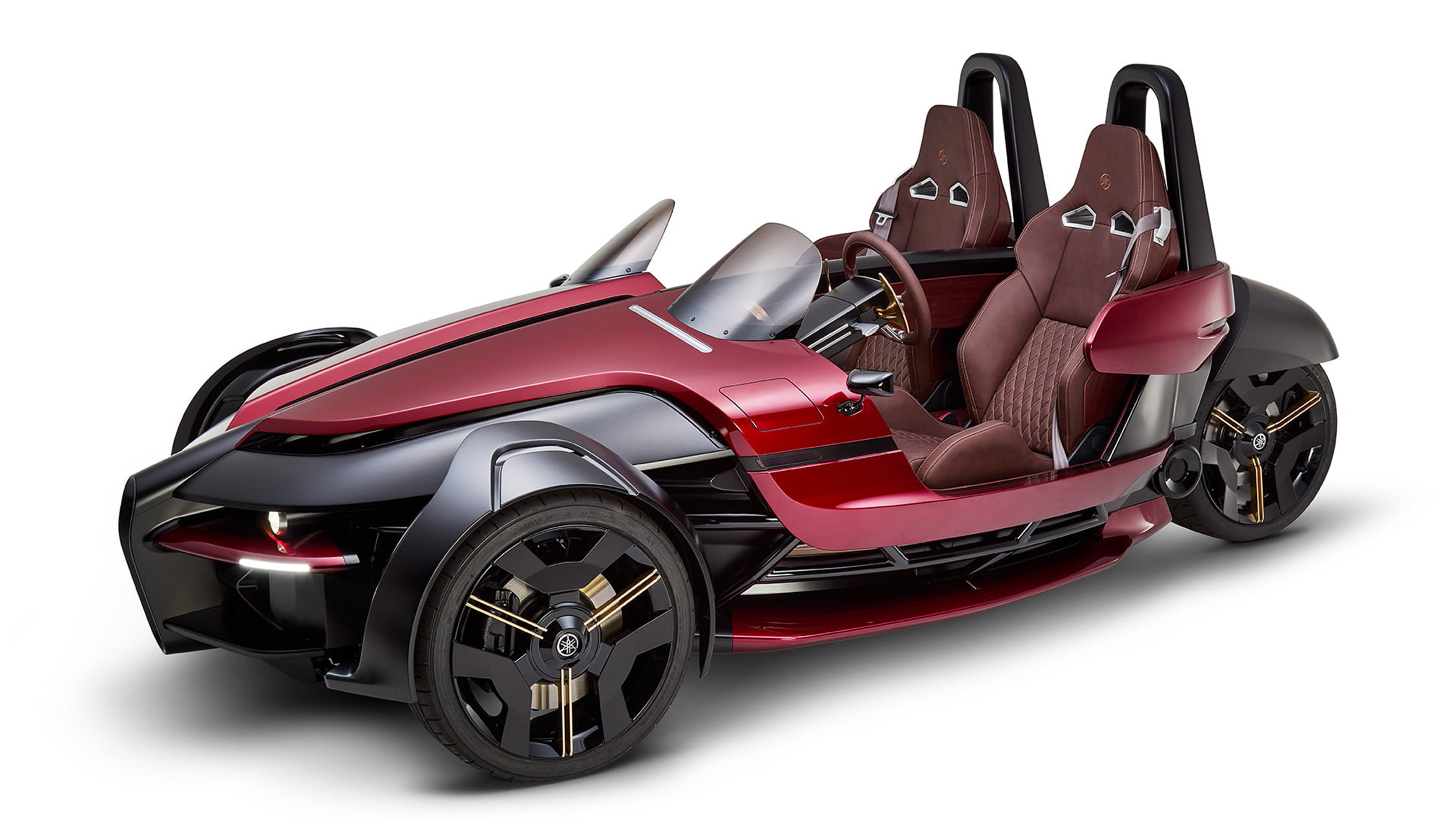 Ein rotes Gefährt mit zwei Rädern vorne, zwei Sitzplätzen und einem Rad hinten