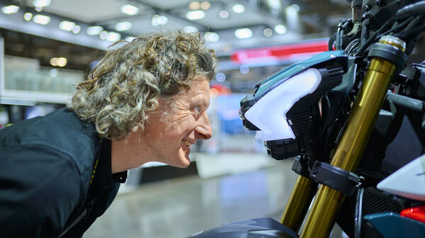 Mann blickt direkt in Motorrad-Scheinwerfer.