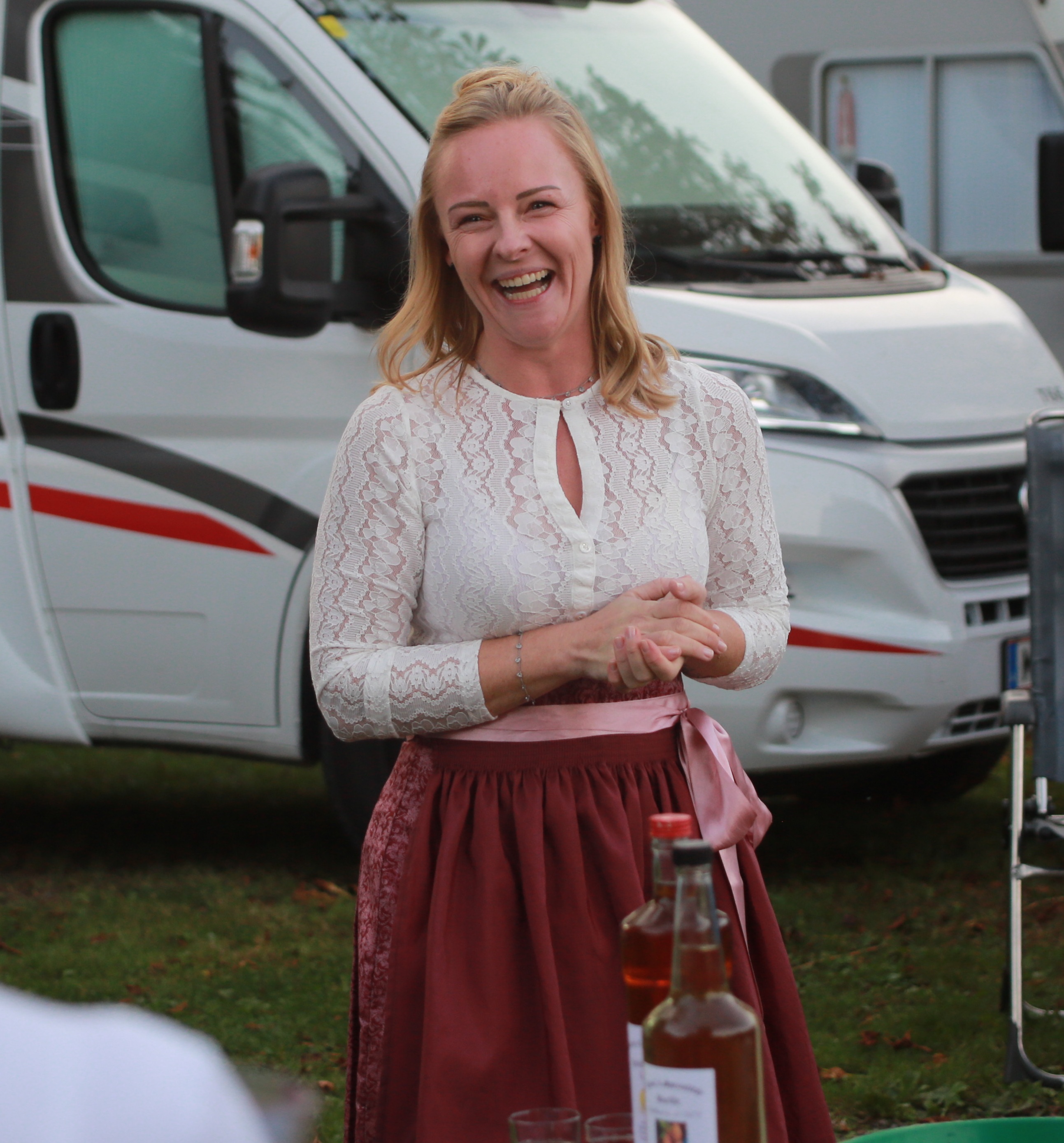 Das Foto zeigt Maria Schwarz, sie trägt ein Dirndl, im Hintergrund ist ein Campingfahrzeug zu sehen.