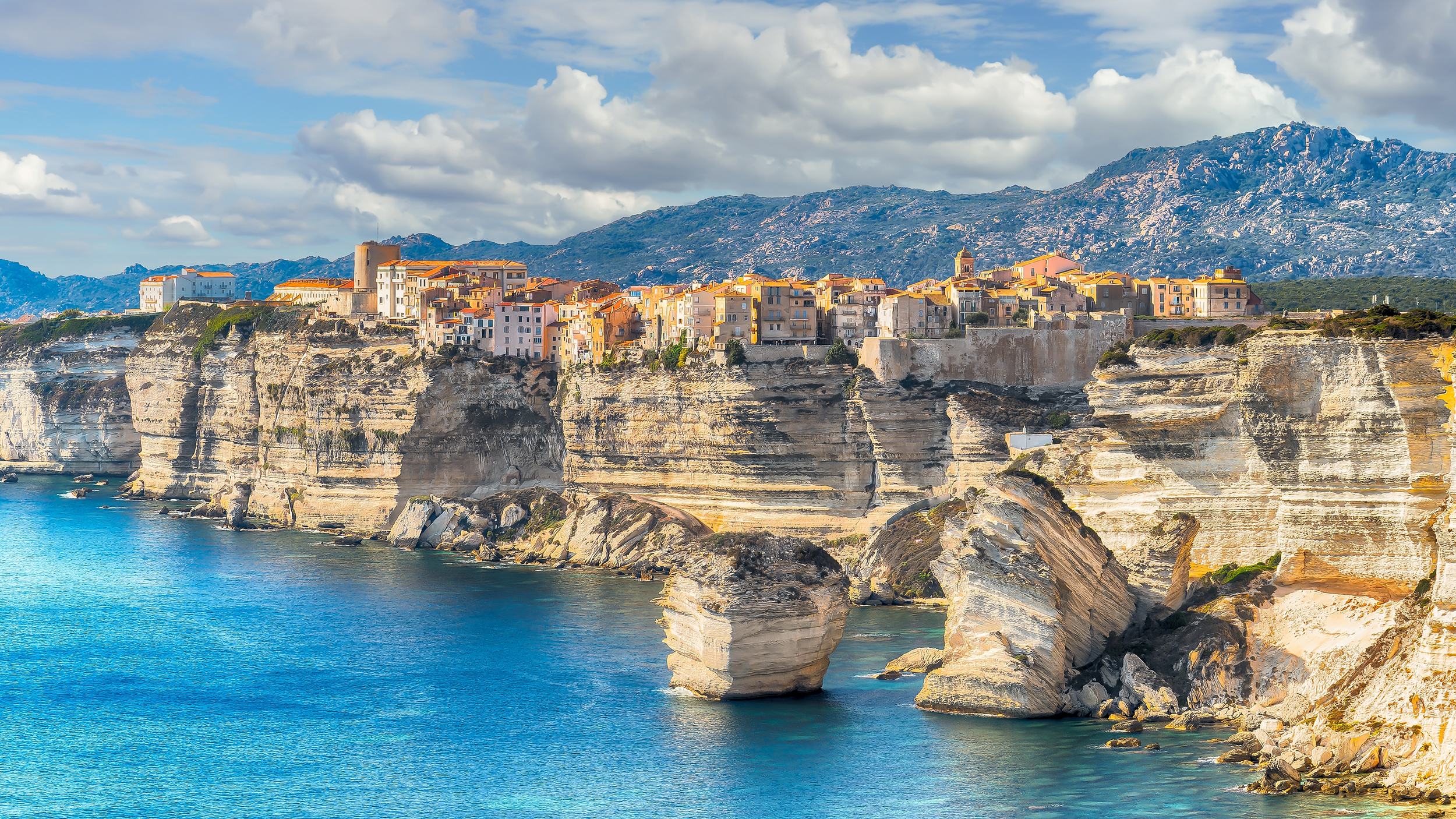 Das Meer mit atemberaubenden Klippen, darauf thront eine kleine Stadt.