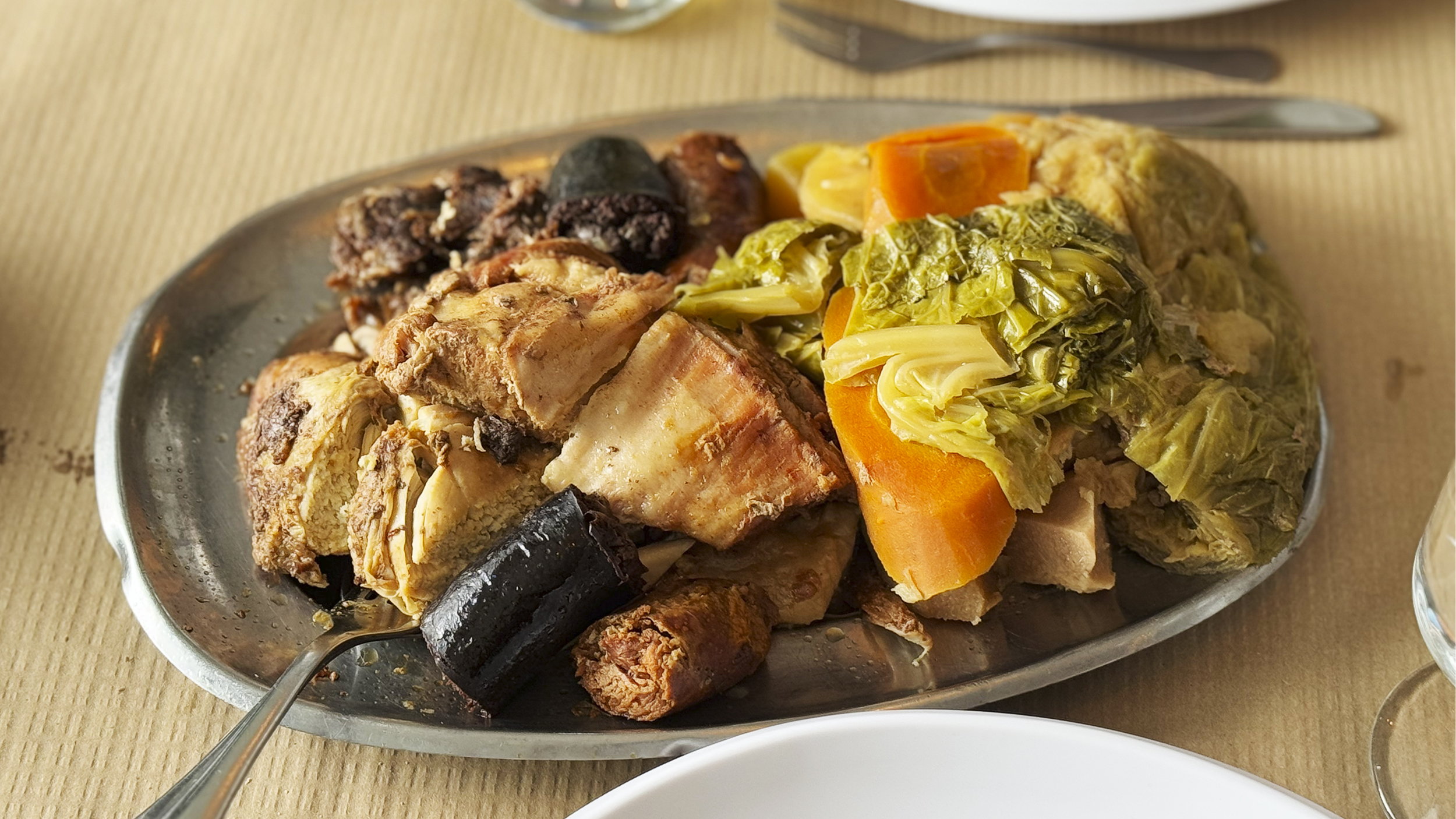 Ein Eintopf mit Fleisch, Blutwurst und Gemüse wie etwa Karotten und Kohl.