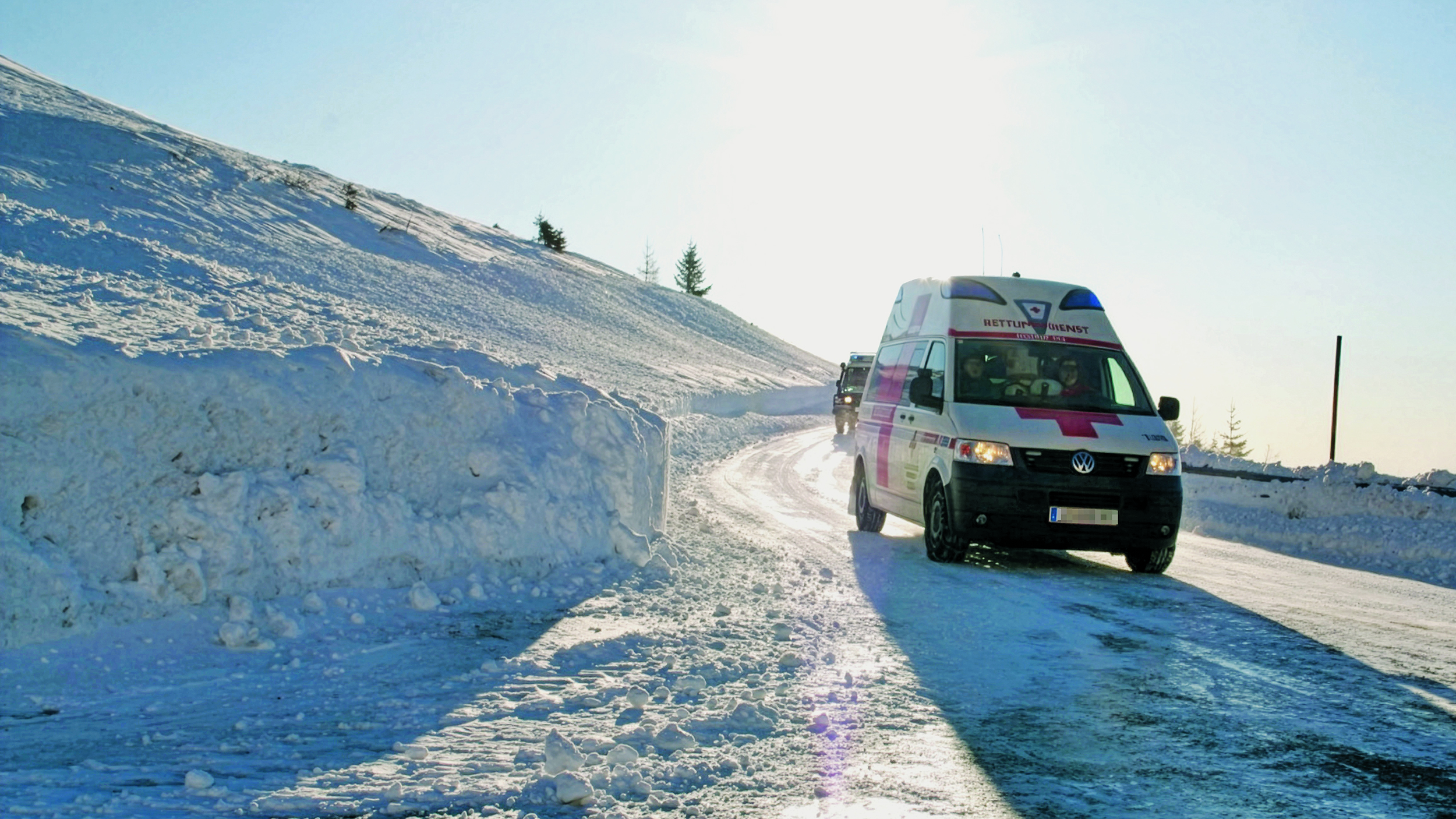 Ein Rettungswagen des österreichischen Roten Kreuz in winterlicher Landschaft.