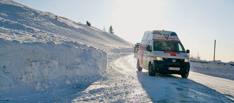 Ein Rettungswagen des österreichischen Roten Kreuz in winterlicher Landschaft.