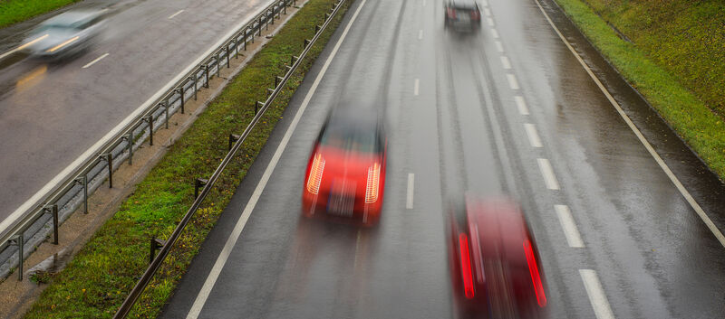 Verschwommenes Bild eines Geisterfahrers in einem roten Auto auf der Autobahn