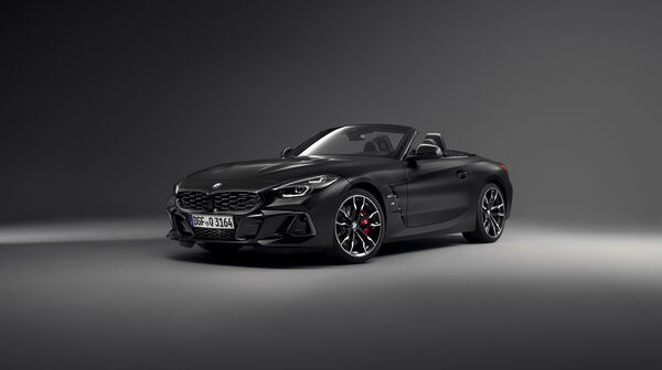 Ein mattschwarzes BMW Z4 Cabrio steht in einem dunklen Studio, von schräg vorne
