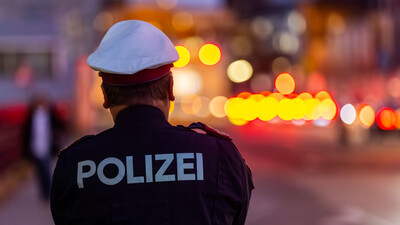 Auf dem Bild sieht man einen Polizisten von hinten, der den Verkehr beobachtet.