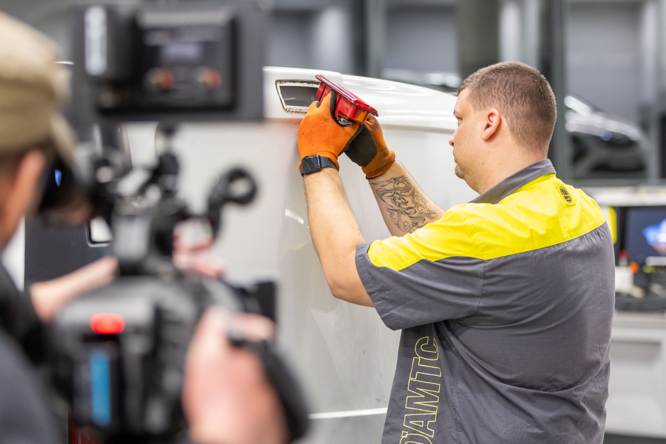 Auf dem Bild sieht man einen ÖAMTC Techniker der das Rücklicht eines Fahrzeuges wechselt