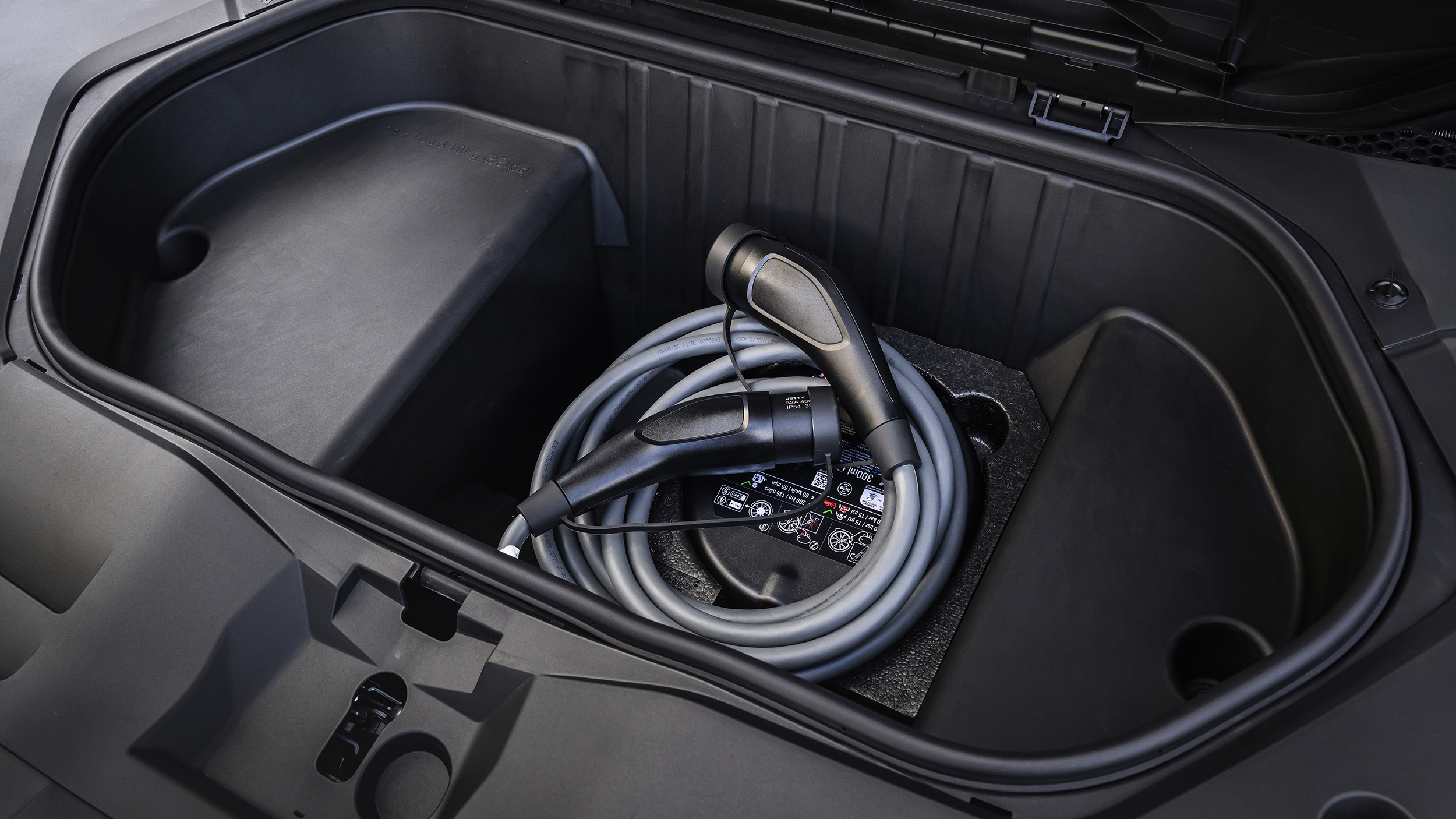 Der Frunk eines Autos, in dem ein Ladekabel liegt.