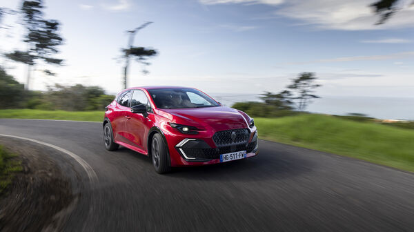 Ein roter Renault Clio fährt um die Kurve.