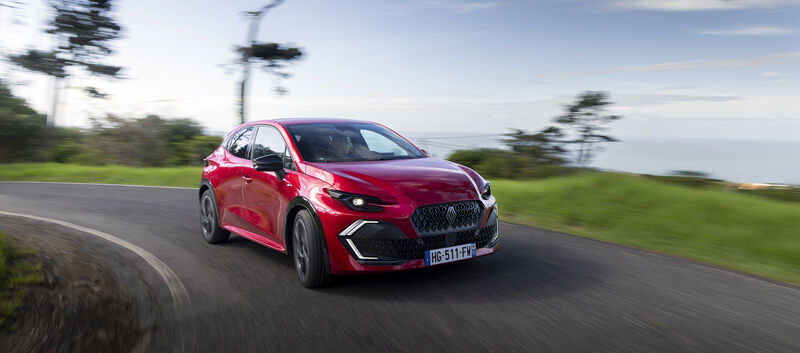 Ein roter Renault Clio fährt um die Kurve.