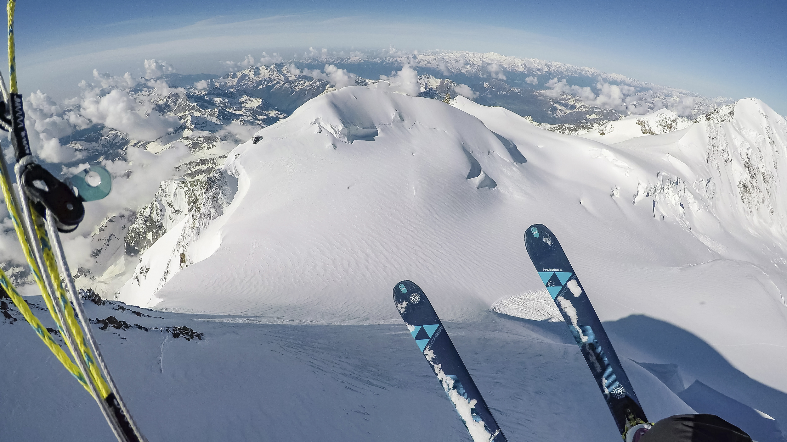 Abfahrt mit Skiern vom Berg. Zu sehen 2 Skier, Schnee und Berge.
