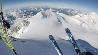 Abfahrt mit Skiern vom Berg. Zu sehen 2 Skier, Schnee und Berge.