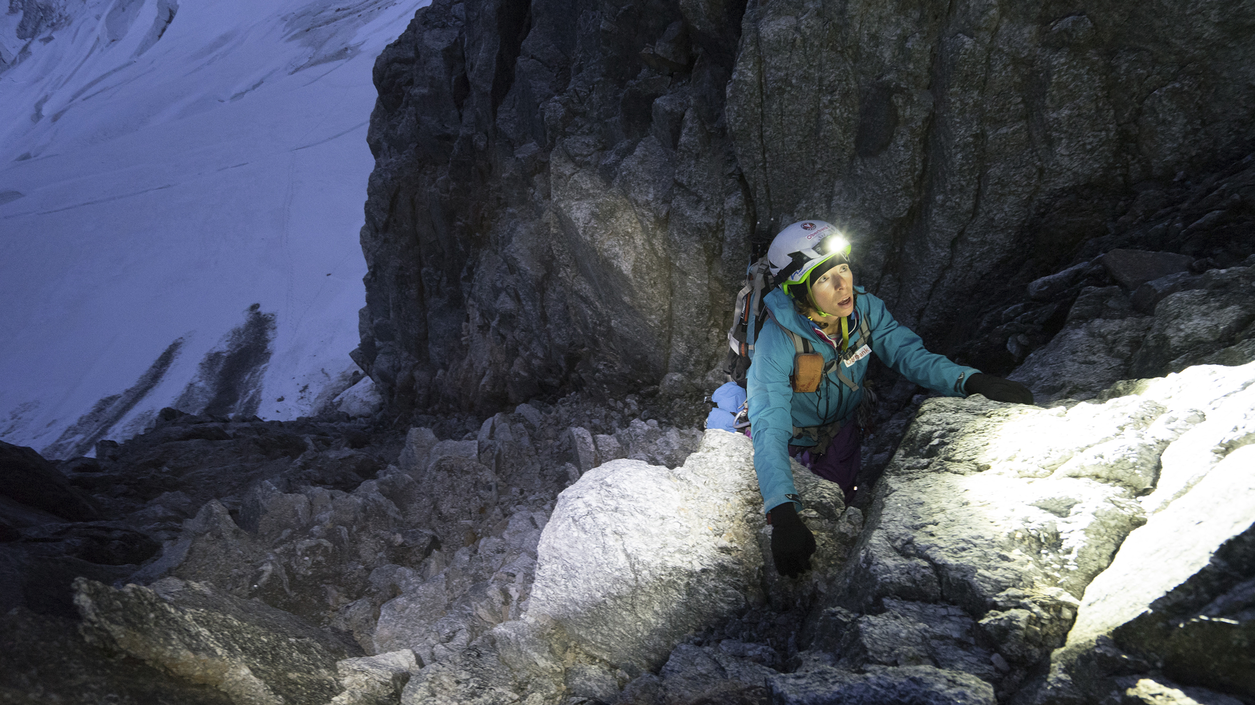 Bergsteigerin Marlies Czerny klettert mit Stirnlampe nachts einen felsigen Berg hinauf.