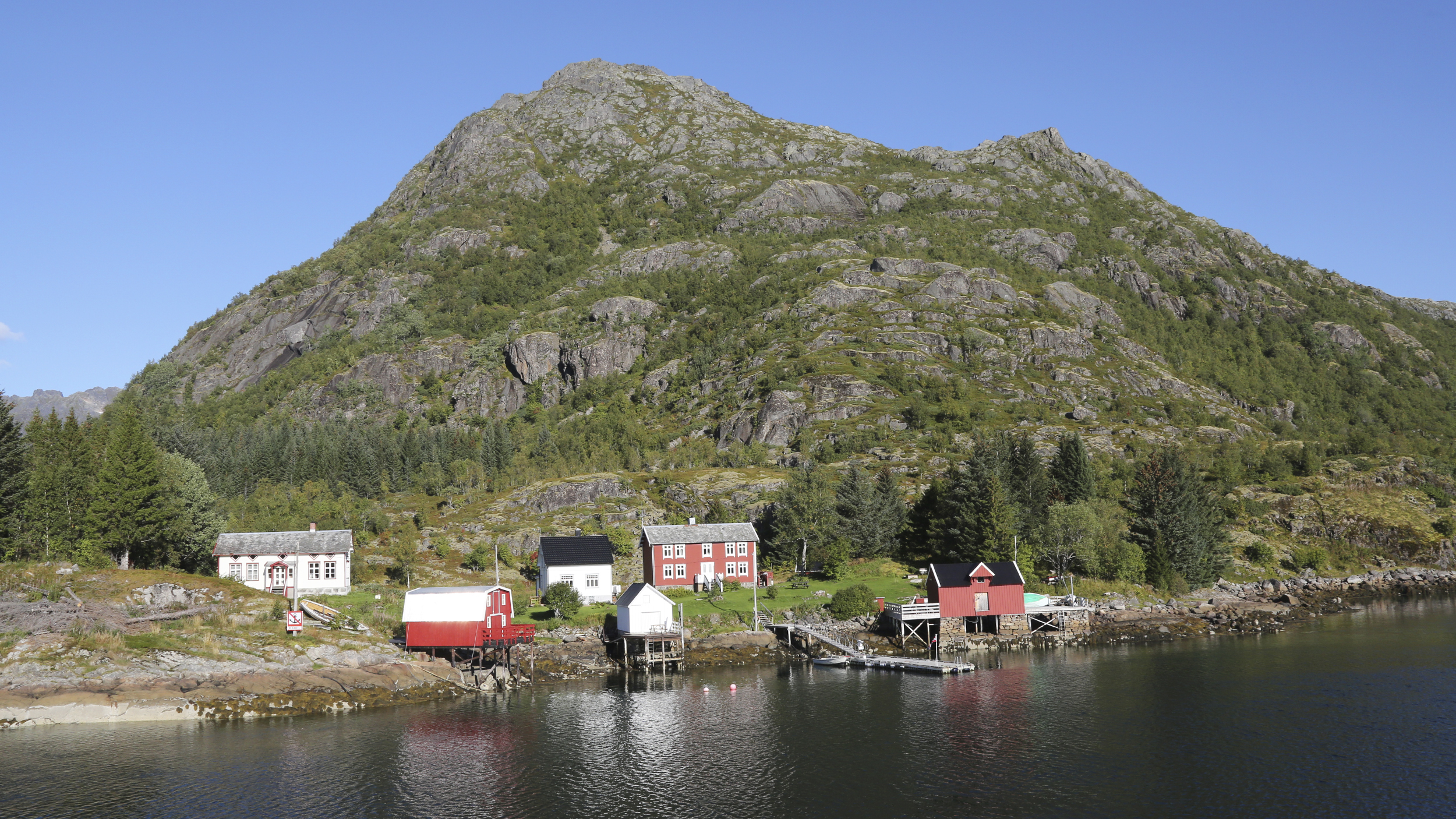 Spektakuläre Küstenlandschaft mit Bergen und ein paar kleinen Fischerhütten.