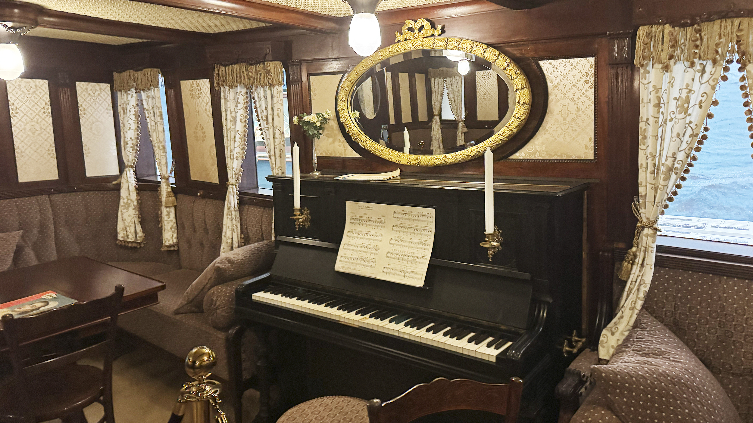 Museum: Ein Lounge am Schiffe mit Klavier und einer Sitzecke.