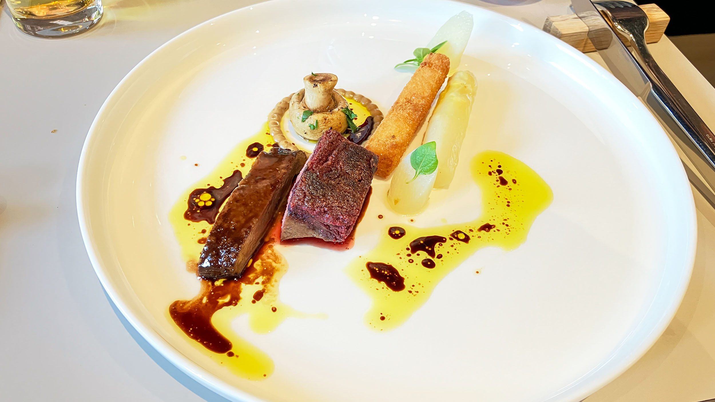 Teller mit Schwetzinger Spargel mit zweierlei Reh, geschmort und mit Purple Curry.