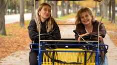 Auf dem Bild sieht man zwei Frauen auf einer Fahrrad Rischka.