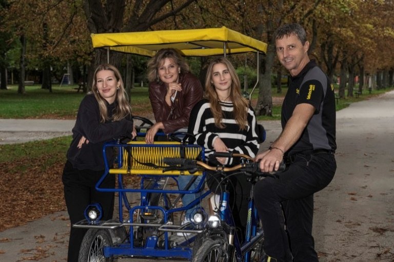 Auf dem Bild sieht man drei Frauen und einen Mann in einer Fahrrad Rischka.