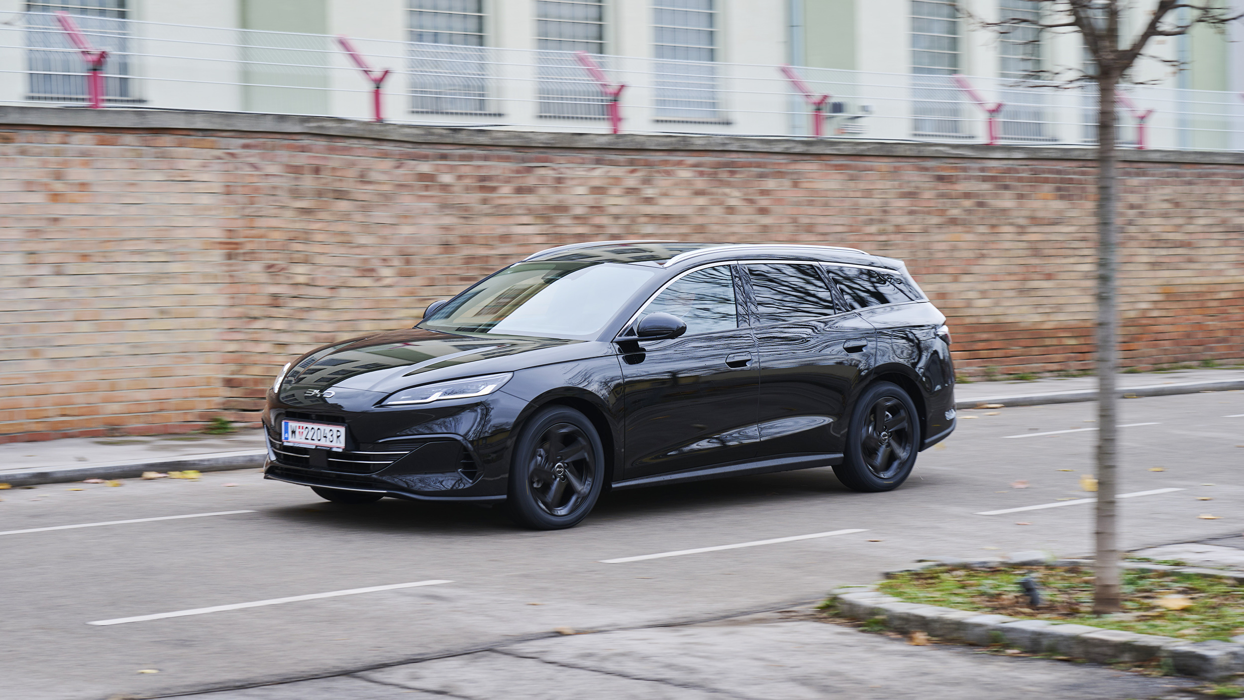 BYD Seal 6 Touring, schwarz vor Backsteingebäude