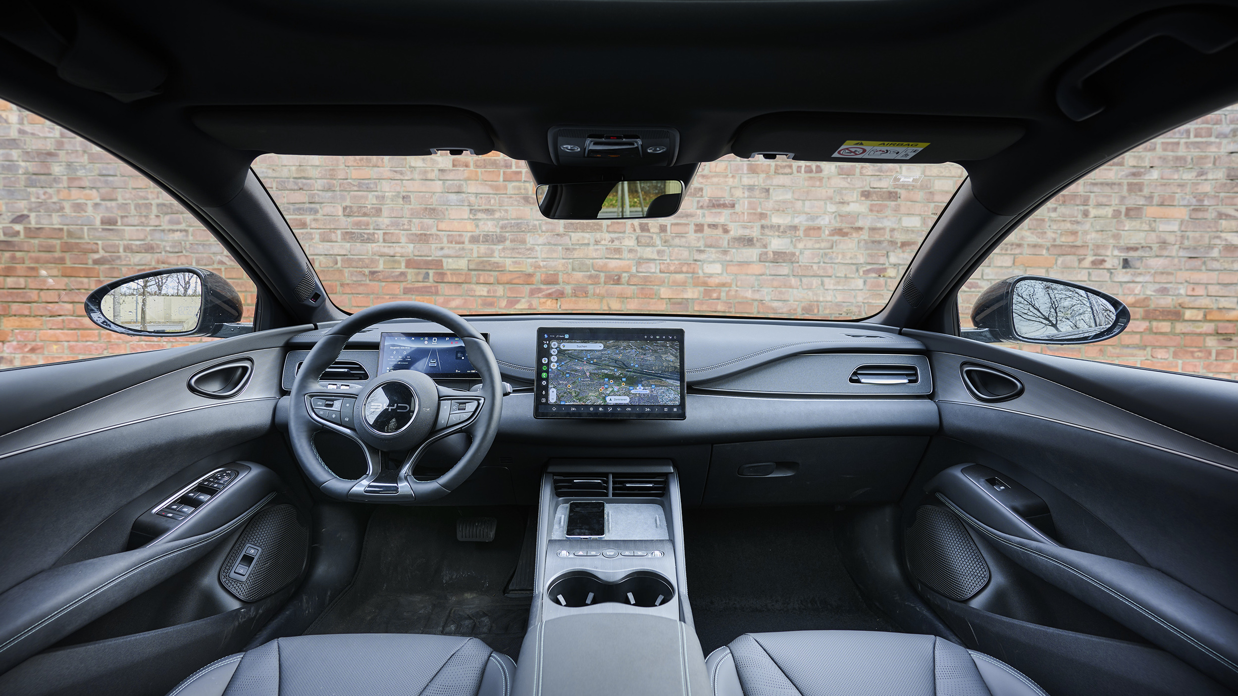 BYD Seal 6 Touring, schwarz vor Backsteingebäude