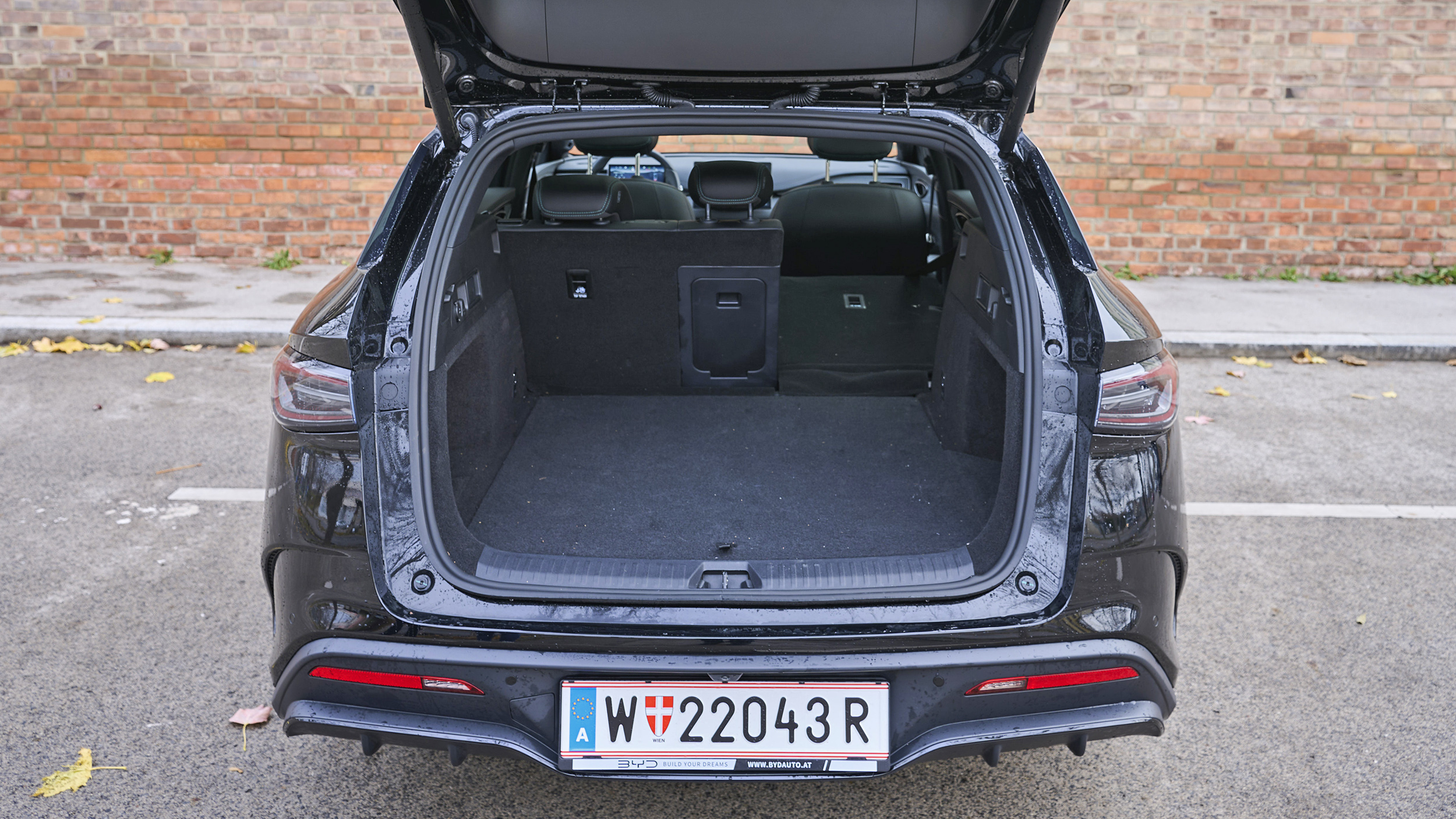 BYD Seal 6 Touring, schwarz vor Backsteingebäude