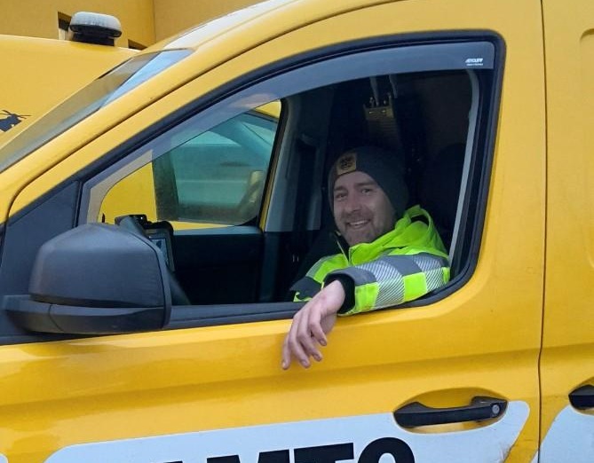 Das Foto zeigt einen ÖAMTC-Pannenhelfer, der im Pannenauto sitzt und aus dem Fenster schaut. 