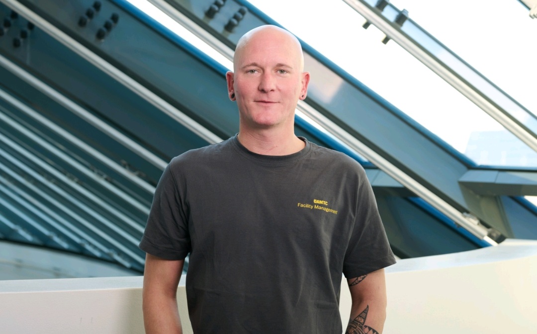 Das Foto zeigt einen Mann mit grauem Shirt.