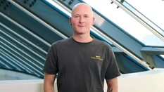 Das Foto zeigt einen Mann mit grauem Shirt.