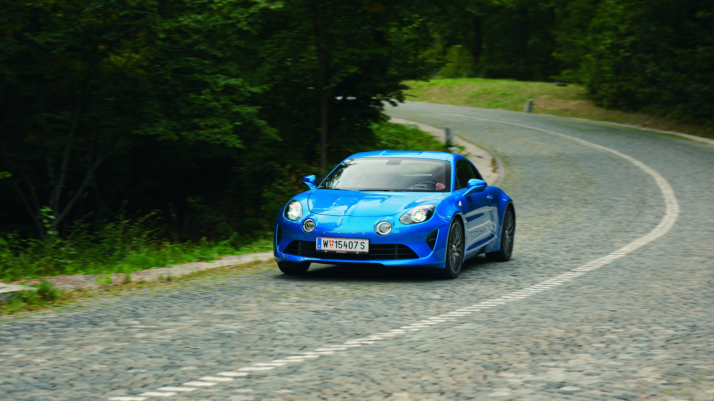 Eine blaue Alpine A110 fährt auf der Höhenstraße