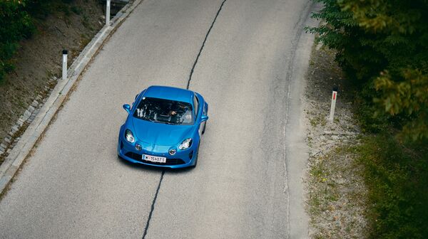 Eine blaue Alpine A110 fährt auf der Höhenstraße, von oben fotografiert