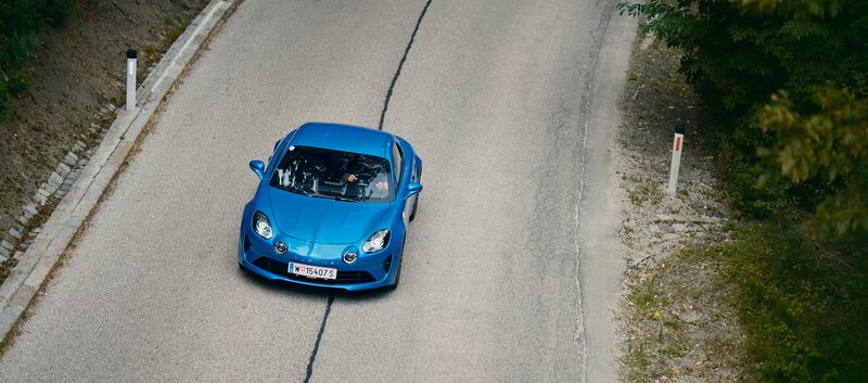 Eine blaue Alpine A110 fährt auf der Höhenstraße, von oben fotografiert