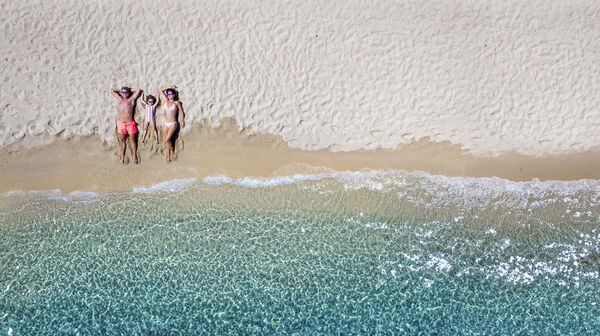 Familie am Strand liegen von oben