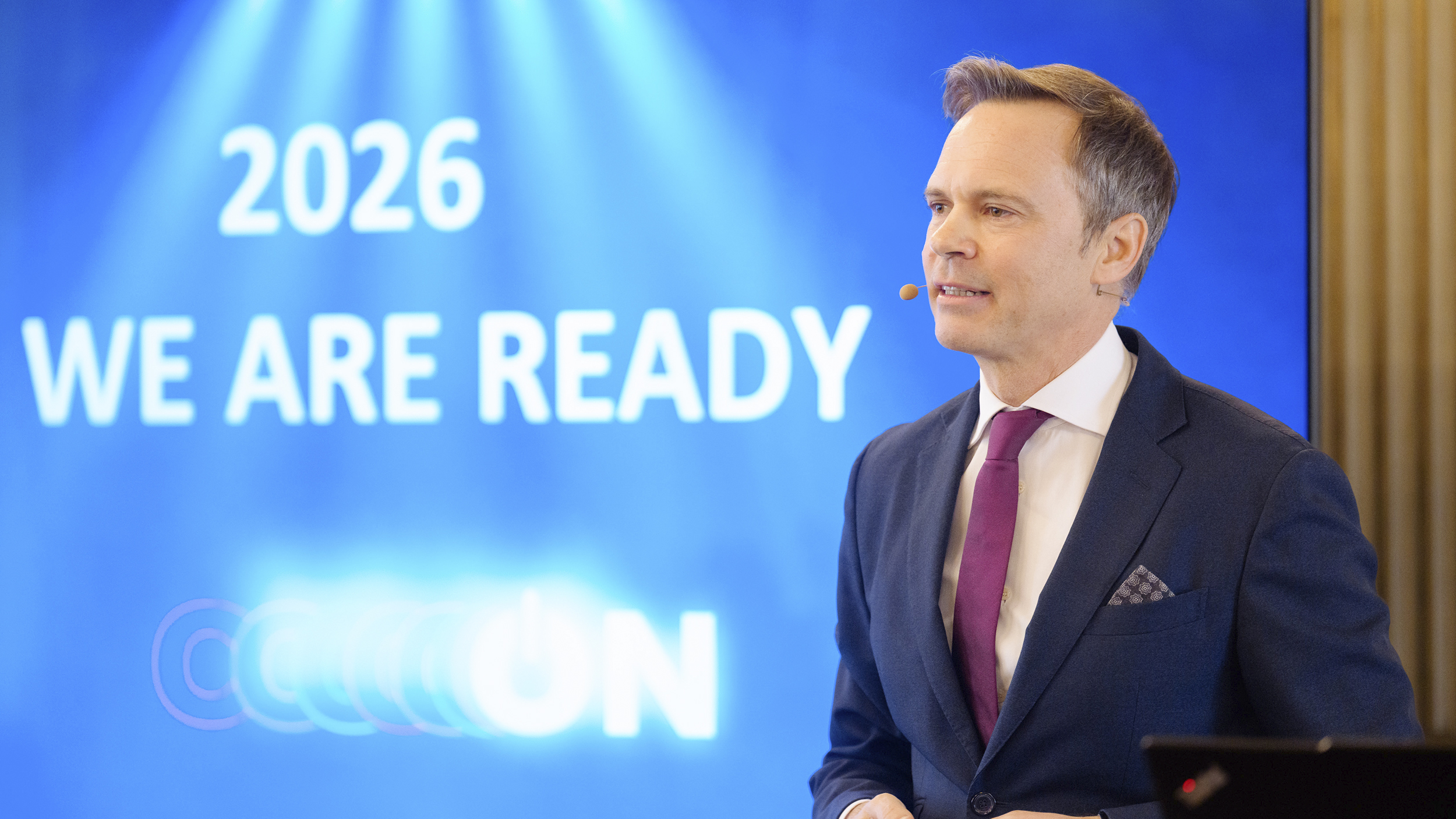 Markus Wildeis, Direktor von Stellantis Austria, steht vor einem blauen Bildschirm.